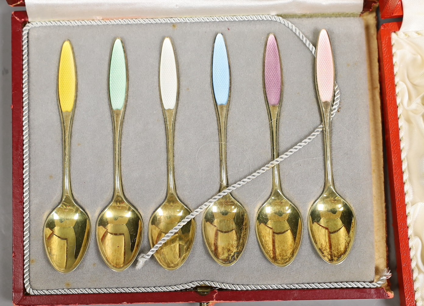 A cased set of eight Danish gilt sterling and polychrome enamelled coffee spoons and a similar cased set of six coffee spoon.